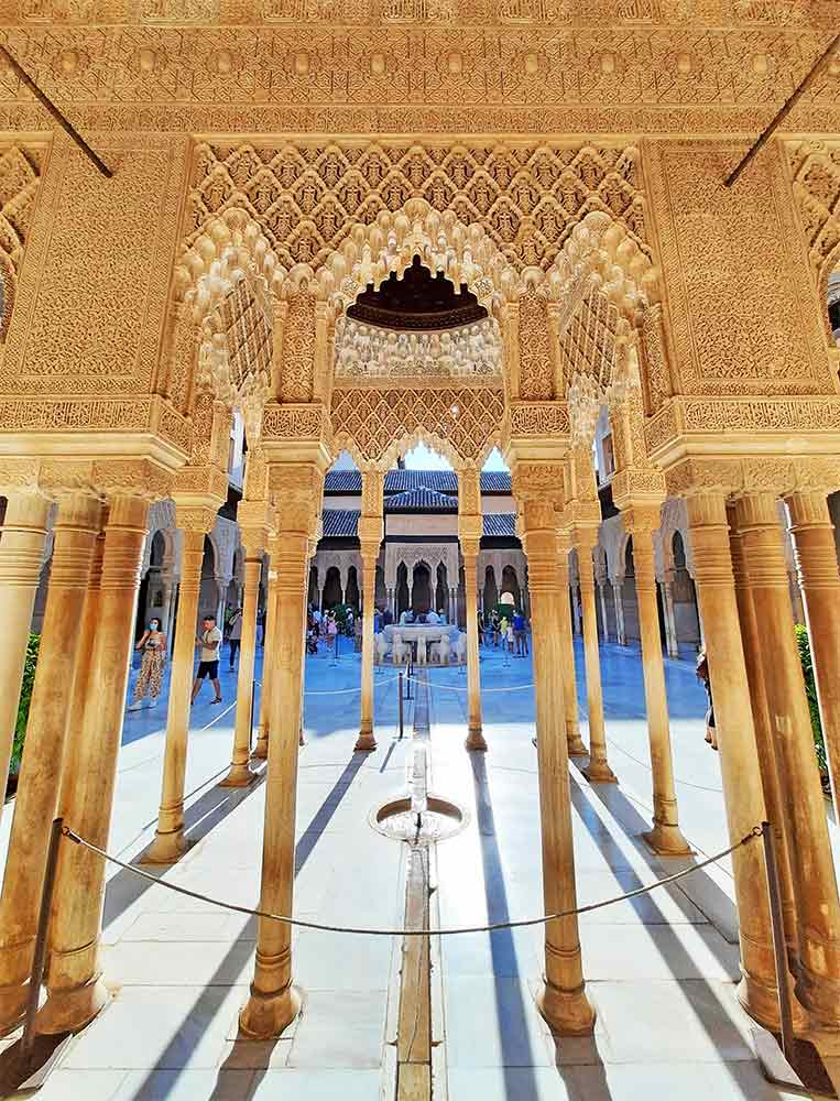 The Nasrid Palaces at the Alhambra in Granada, Spain. White markble columns in a white marble couryardwith decorative lattice work stretched between the coloumns. A definate must see during 2 days in Granada