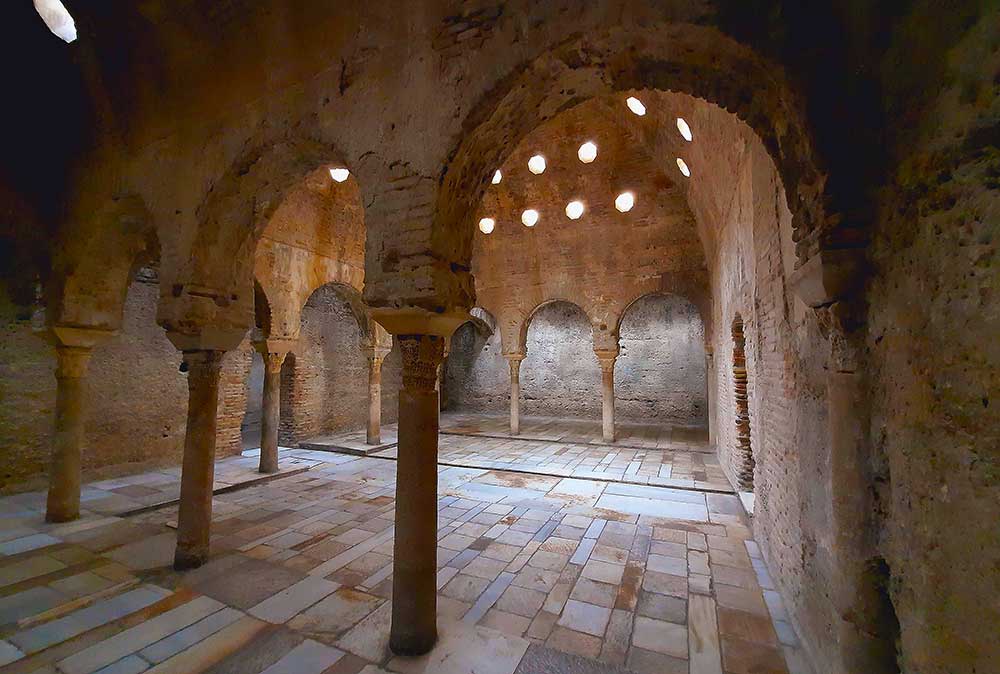 El Banuelo showcases its arch with columns on a sandstone structure with patterns tiles