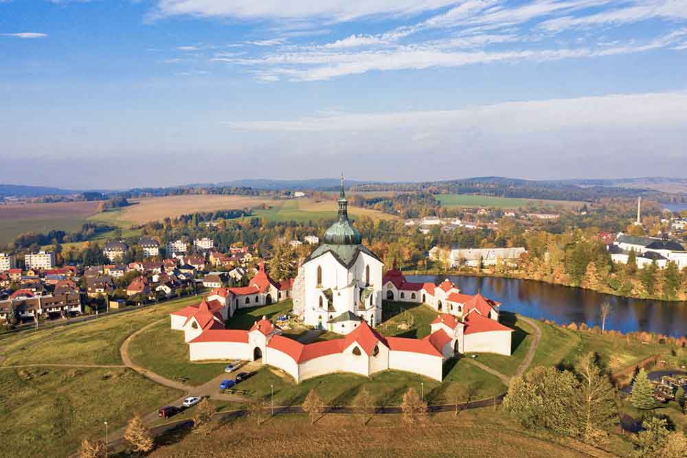A white star shaped building with red roofs with a church in the middle. 