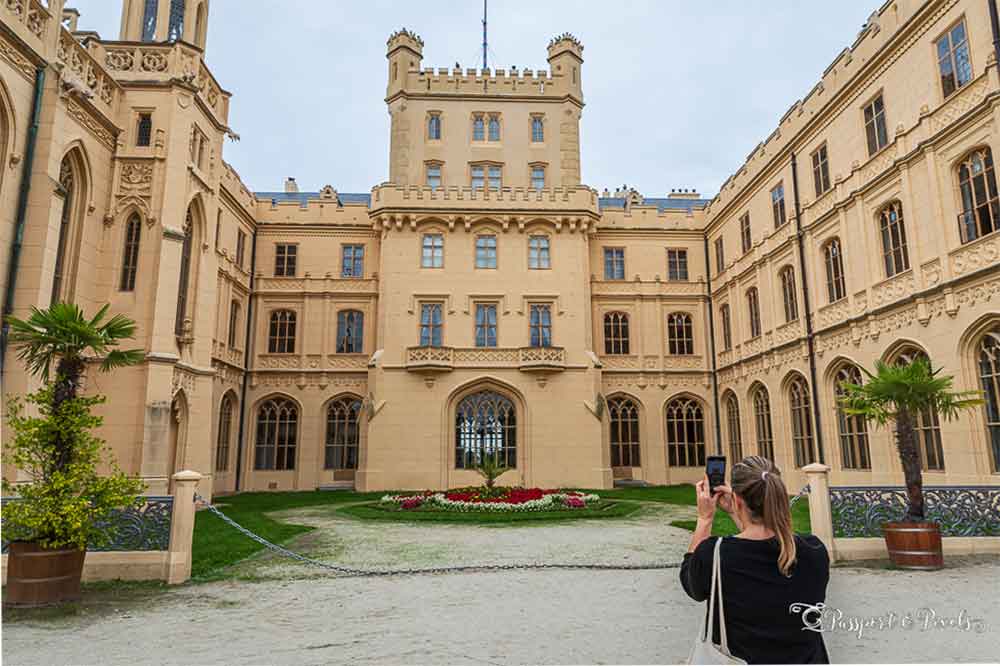 Lednice Chateau  with a small courtyard and a woman in the foreground taking photos. 