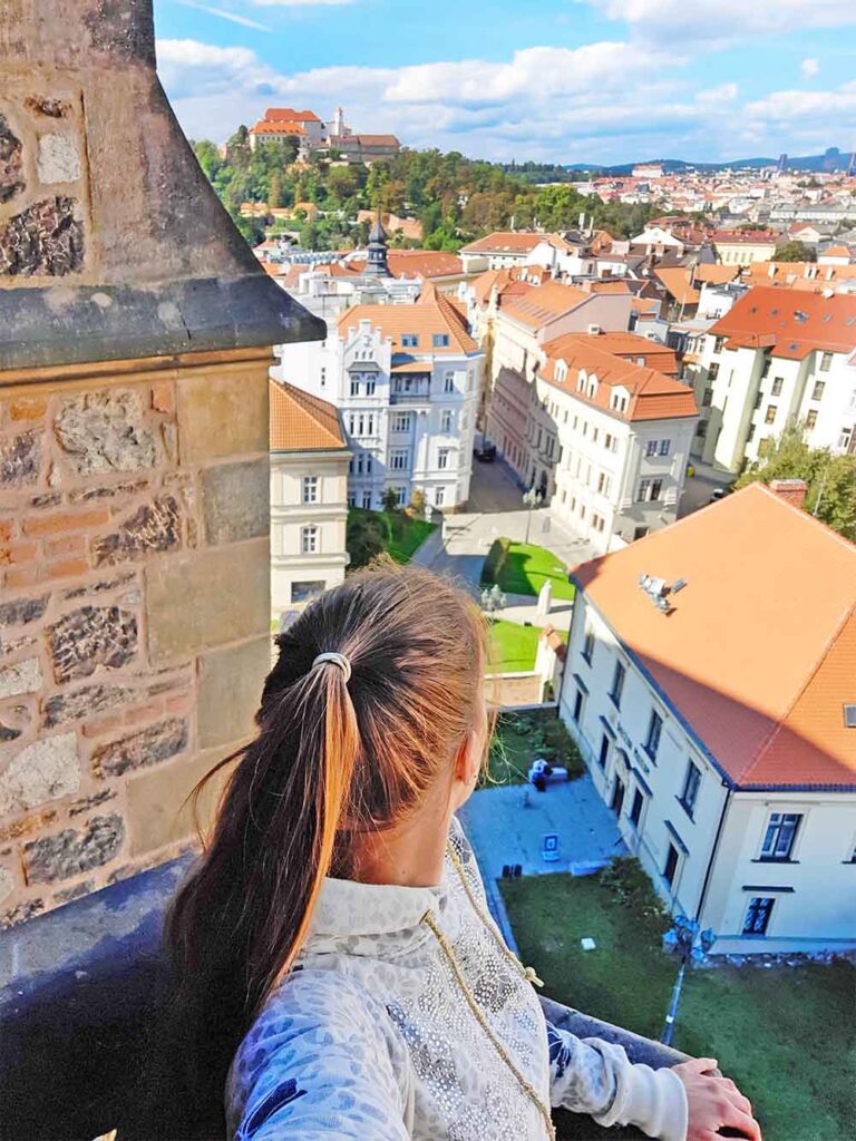 A view from the balcony of a church spire looking out over Brno old town with Spilberk Castle in the background. 