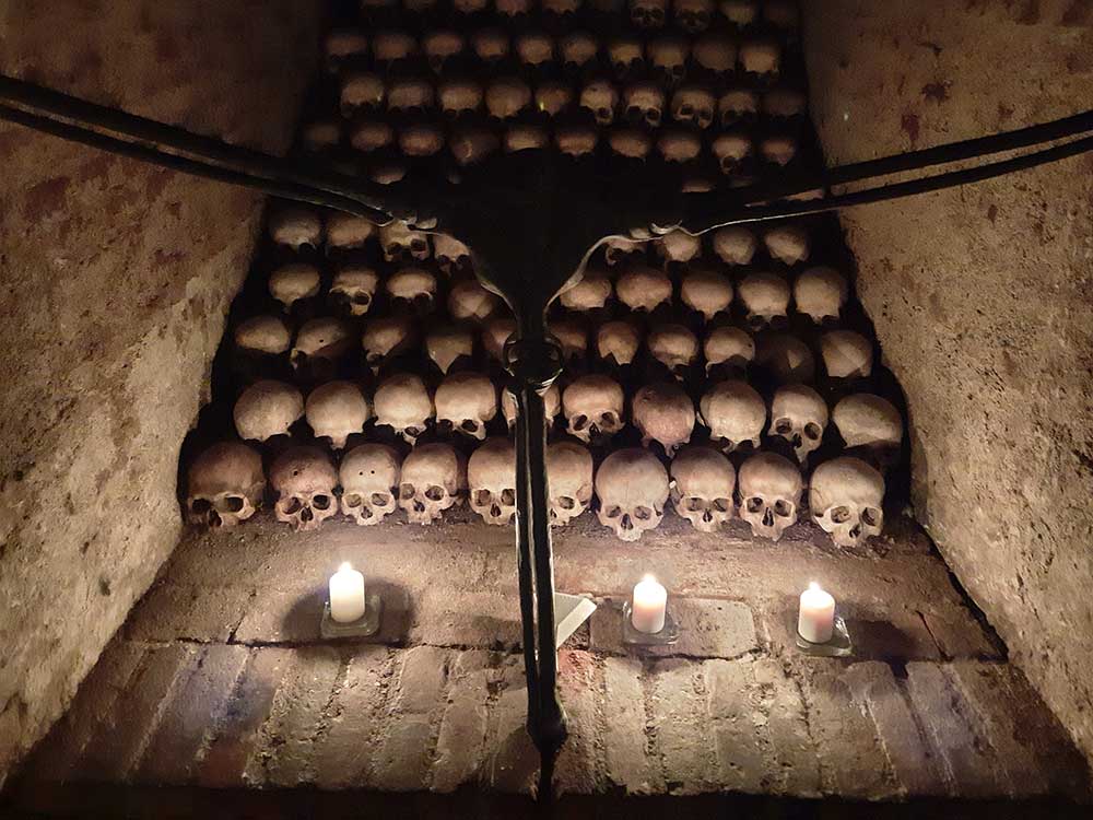 Rows of skulls lit by candlelight 