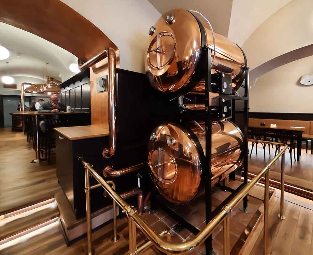 Inside a bar called Zvon with their copper beer tanks