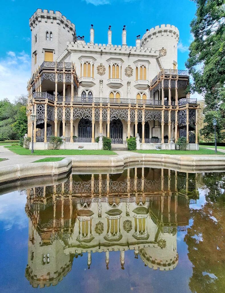 The pond and gardens at Hluboka with a reflection of the caslte in the water.