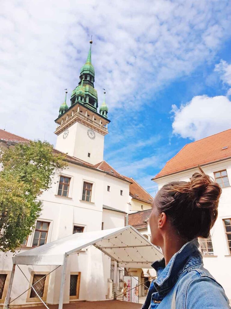 The inner courtyard of the Old Town Hall looking up at the spire with a green pointed roof. 
