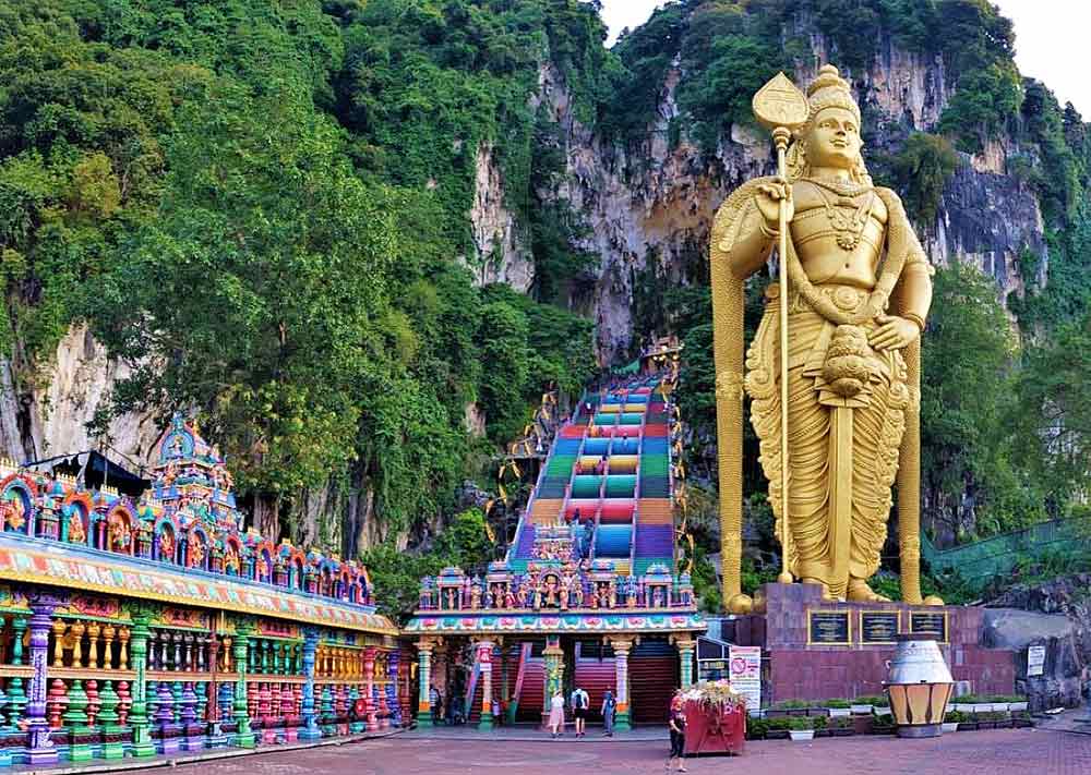 Batu Caves in Malaysia features a colorful steps that lead up the hill along with a giant golden Murugan Statue, one of the tallest statues in the world