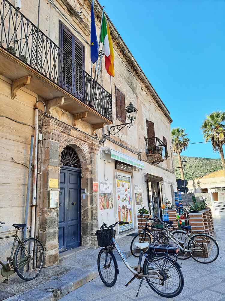Favignana Cetnre with bikes parked outside an old building. 