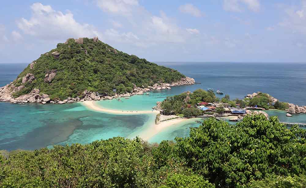 Aerial view of the Kho Tao in Thailand featuring an islands with lush green trees surrounded by turquiose sea water