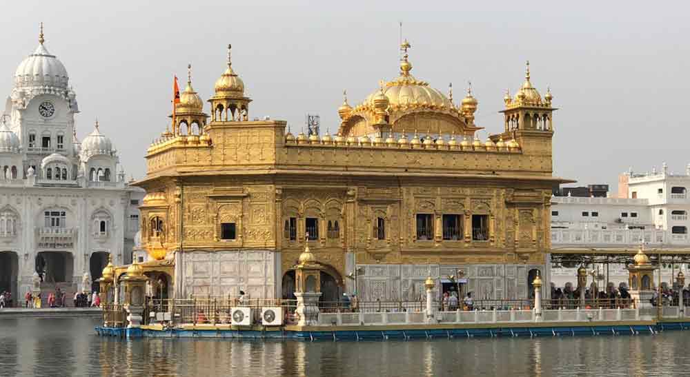 Sri Harmandir Sahib or Golden Temple in India features a small multiple dome lined in a row and large dome roof at the top of the temple surrounded by water