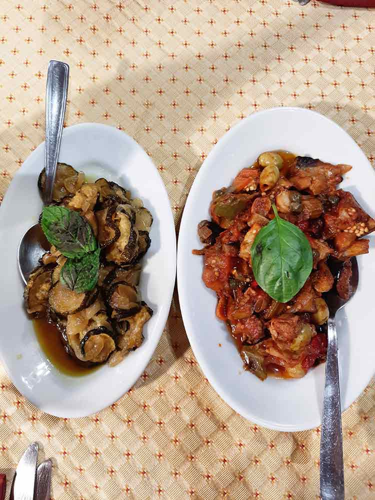 Traditional Sicilian dishes, Caponata (right) and corgette and garlic (left)