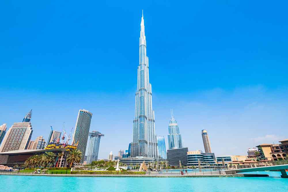 Burj Khalifa located at Dubai, United Arab Emirates - one of the tallest building in Dubai surrounded by buildings and water with a clear blue sky