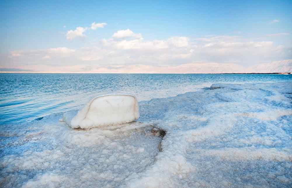 Dead Sea located in North Jordan, a saltwater lake known for its extreme mineral content line with white, salt-encrusted formations