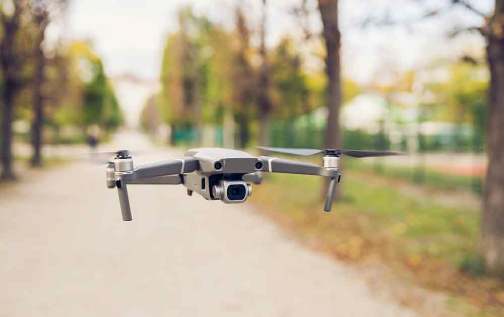 Wondering if you can fly a drone in Prague, Czech Republic? This informative article tells you everything plus information on the best photo spots in Prague. Image of a drone flying against the backdrop of a park.
