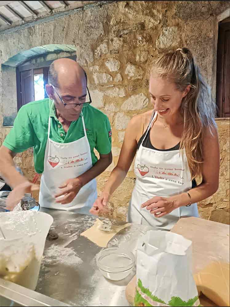 A photo of two people - one of them is me - making cassatelle pasta.