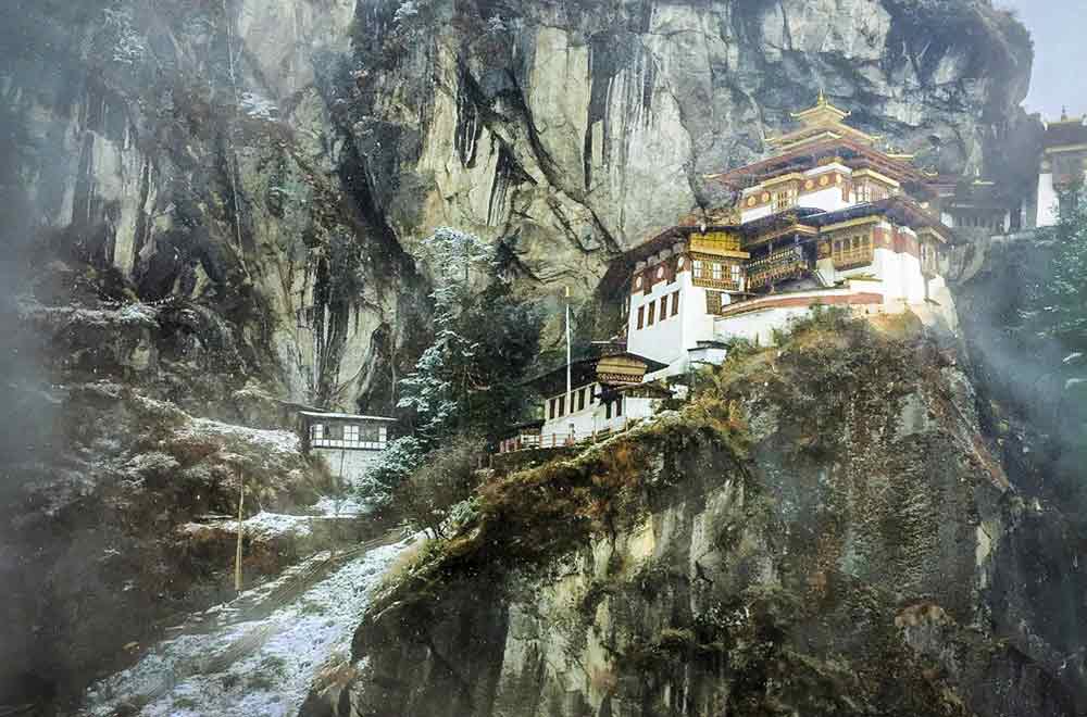 Tiger's Nest Monastery in Bhutan is perched high in the mountains against a craggy cliffside