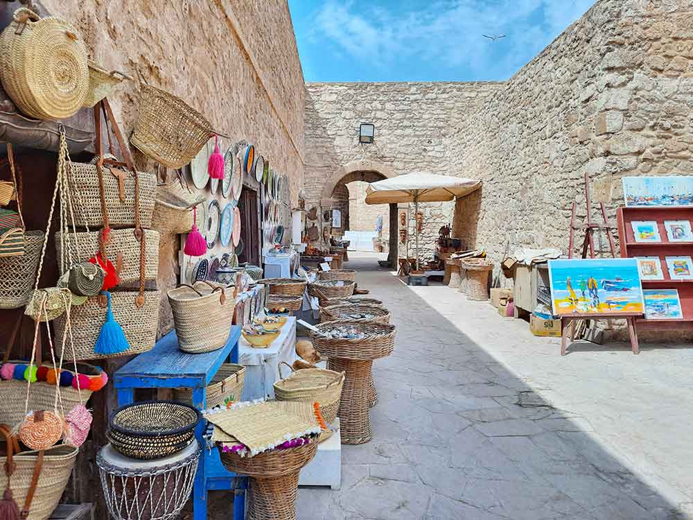 The Old Medina of Essaouira showcases whitewashed cobblestone walls along with the bustling shops in the streets filled with local vendors selling bags, artworks and paintings