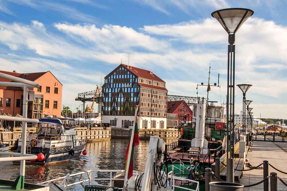 Best Of The Baltics: 23 Unmissable Things To Do In The Baltics 19 Klaipeda along with charming riverside pathway lined with lovely historic ships surrounded by buildings