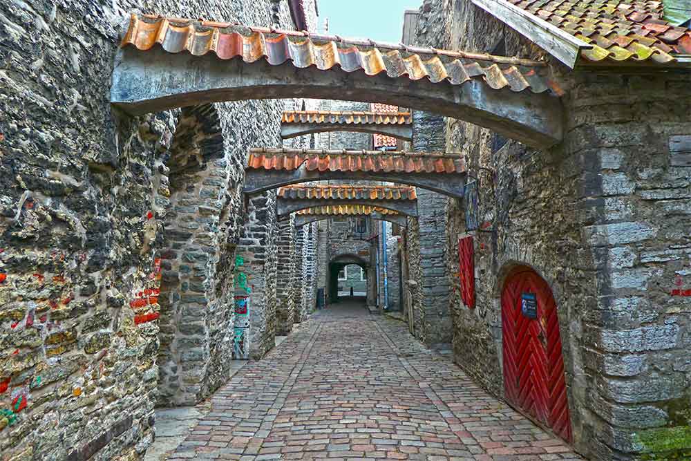 Best Of The Baltics: 23 Unmissable Things To Do In The Baltics 2 Stone brick walls and a passage with a red door and window on the side at St. Katherine's Passage, Tallinn.