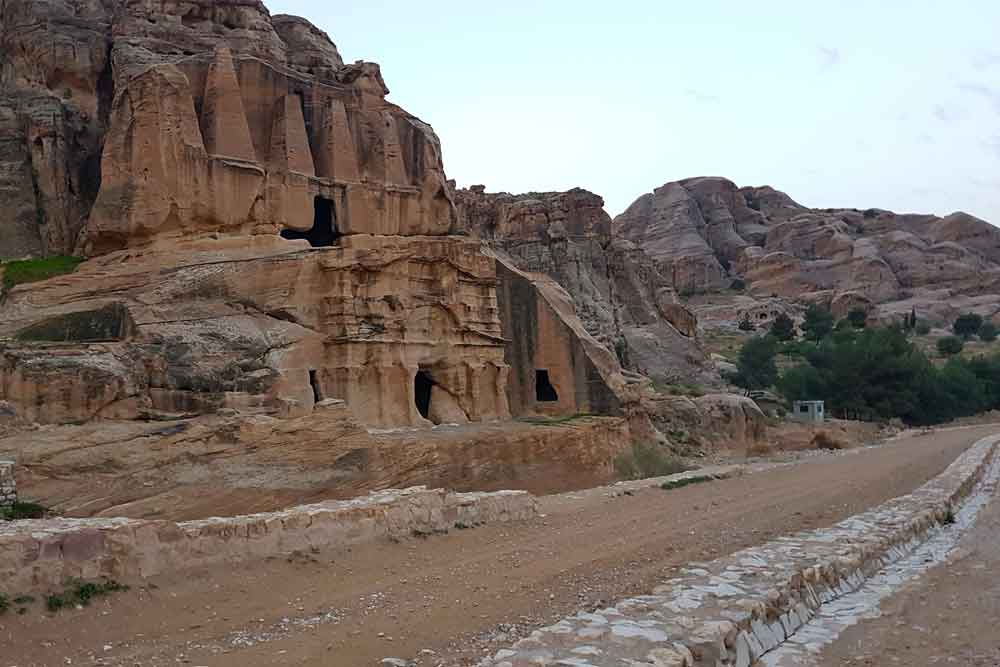 Best 2 Days in Petra Itinerary: Self-Guided Two Days in Petra, Jordan 5 Bab Al Siq in Petra Jordan featuring a small entrance on a large rock formation on a sand stone color