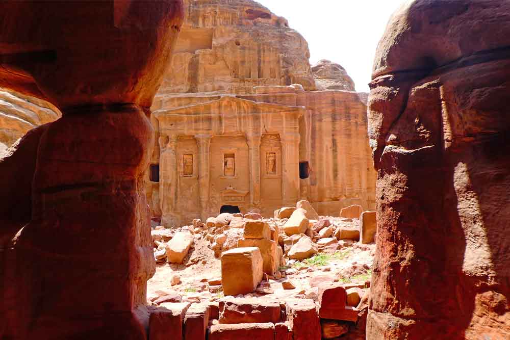 Best 2 Days in Petra Itinerary: Self-Guided Two Days in Petra, Jordan 19 The Tomb of the Roman Soldier in Petra, Jordan, presents a large sandstone rocks surrounded - with a view of the tomb adorned with carved columns.