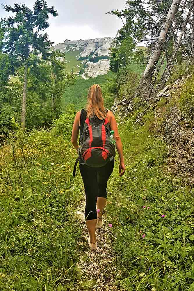 A woman with a red bag is hiking up to Pljesevica