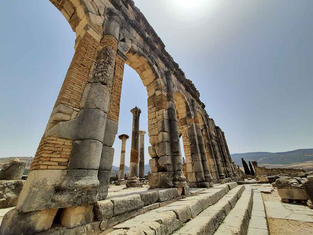 Ruins structures with a variety of cobblestone stands in the Roman City of Volubilis on a sunny day