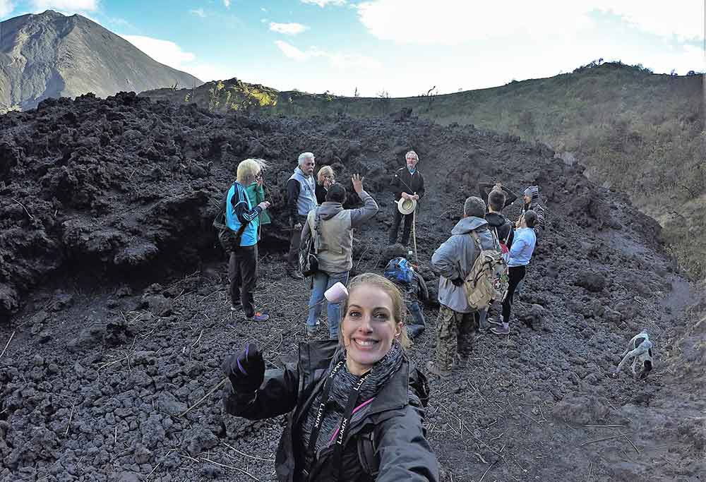 A woman taking a selfie in Volcan Pacaya "Mashmallow Hike" with group of people in the background
