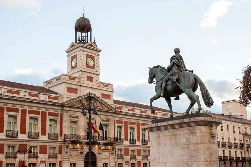 Plaza Major features a red-brick building and a statue of man riding a horse