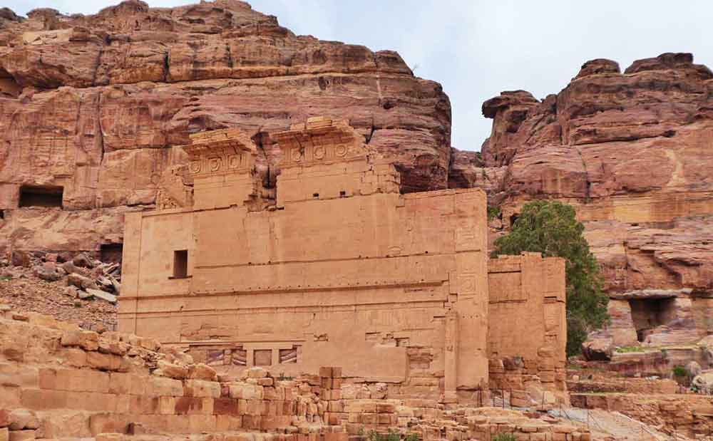 Best 2 Days in Petra Itinerary: Self-Guided Two Days in Petra, Jordan 24 Qasr Al-Bint in Petra, Jordan featuring a fallen walls and old stones with a background of large rock formations