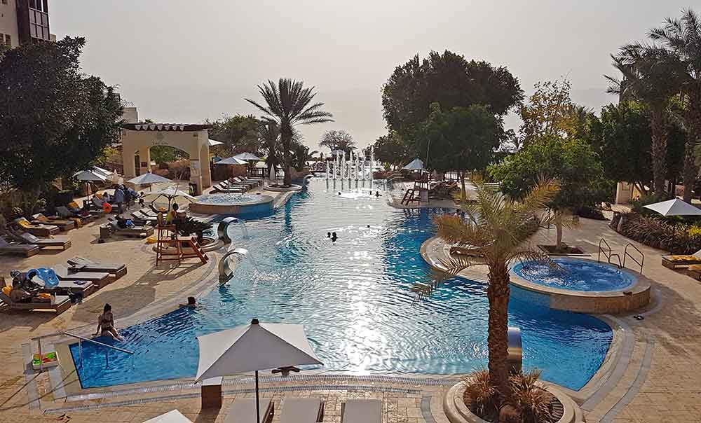 The Dead Sea Marriott features a large pool, trees and umbrellas