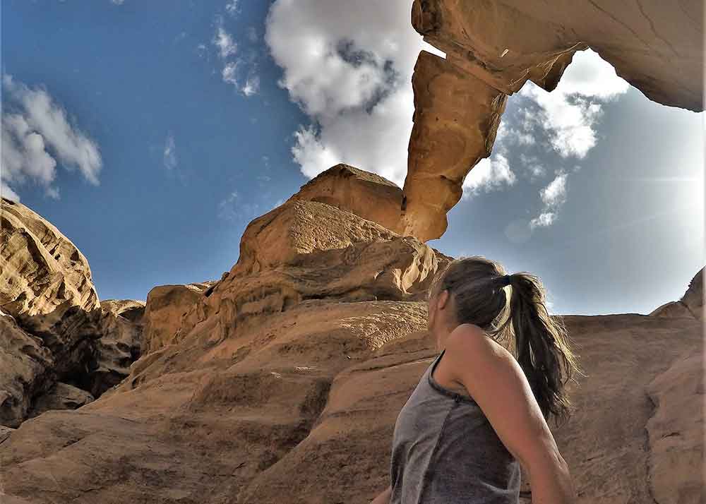 Me with a large rock bridge in Wadi Rum desert.