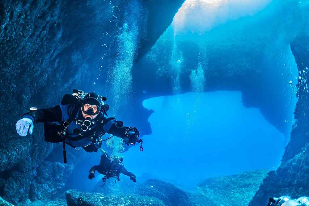 Two scuba divers are exploring the sea in Gozo