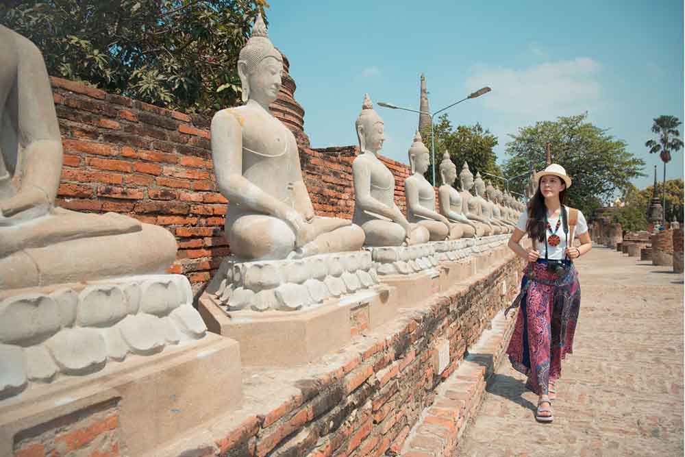 Is Bangkok Worth Visiting? 16 Great Reasons to Visit Bangkok 19 A young woman with a hat is walking along the Ayutthaya Ruins
