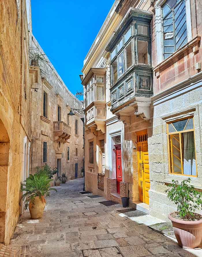 One Week in Malta: The Best 7 Days in Malta Itinerary 9 The narrow street in the District of Birgu/Vittoriosa in the Three Cities features a red and yellow door