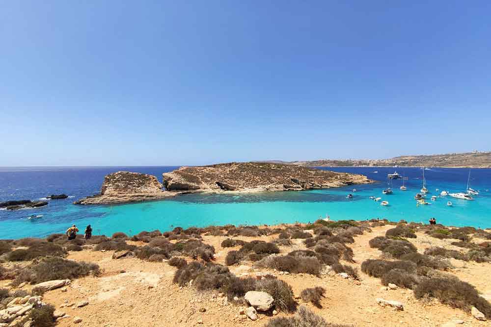 One Week in Malta: The Best 7 Days in Malta Itinerary 26 The Blue Lagoon features blue and turquoise waters with a large rock in the middle, all under a sunny day