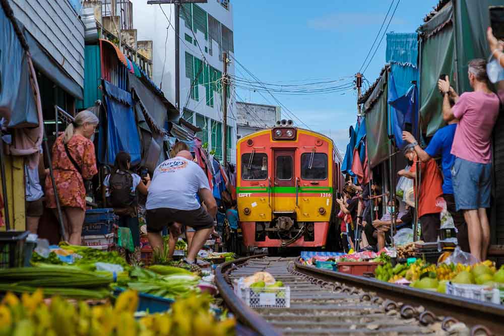 Is Bangkok Worth Visiting? 16 Great Reasons to Visit Bangkok 13 Shopkeepers retract their goods when the train approaches at Maeklong Railway Market