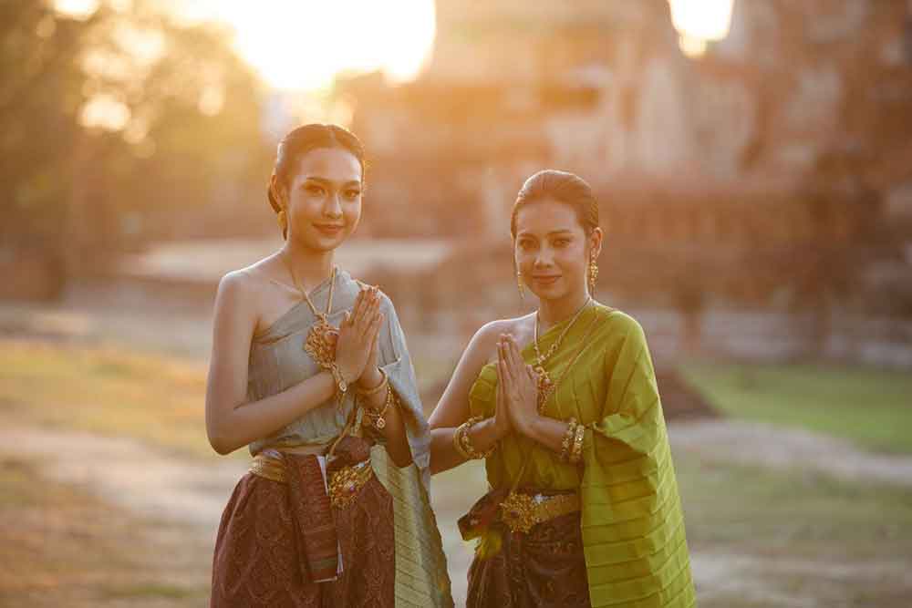 Is Bangkok Worth Visiting? 16 Great Reasons to Visit Bangkok 17 Two Thai women are smiling while dressed in their traditional attire