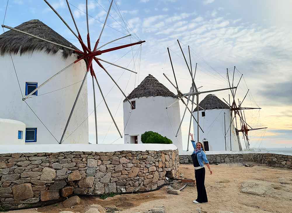 I am standing with the Mykonos Windmills at sunset