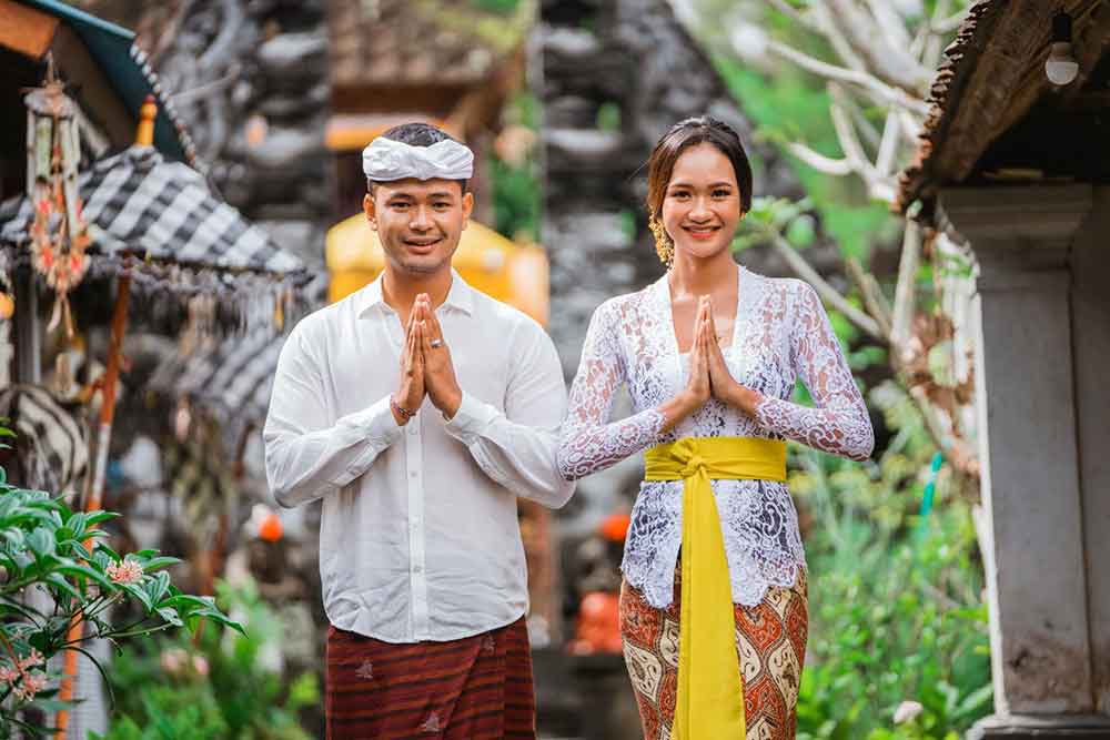 Two hindu people - a man and woman smiling with a two hands pressed together gesture