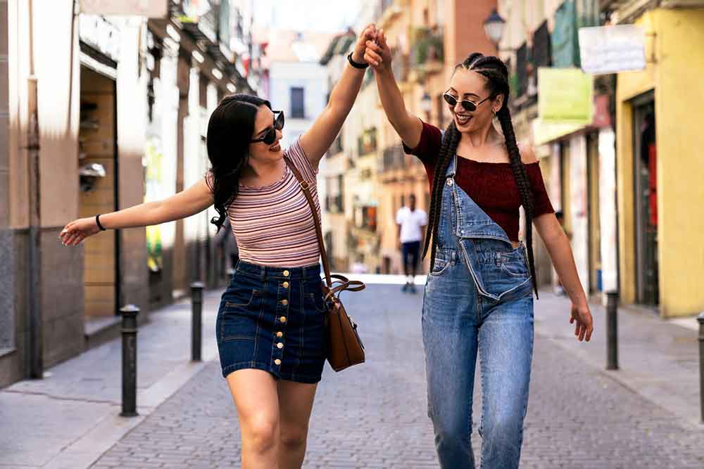 Two women walking down the street of Madrid, enjoying themselves