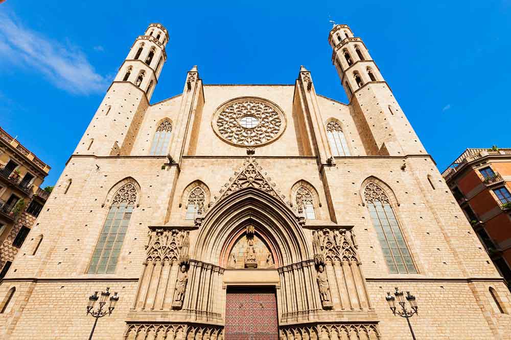 Barcelona Bucket List: 32 Best Things to Do in Barcelona, Spain 16 Santa Maria Del Mar - a Gothic church in a cream-white color, featuring a unique entrance structure adorned with detailed carvings
