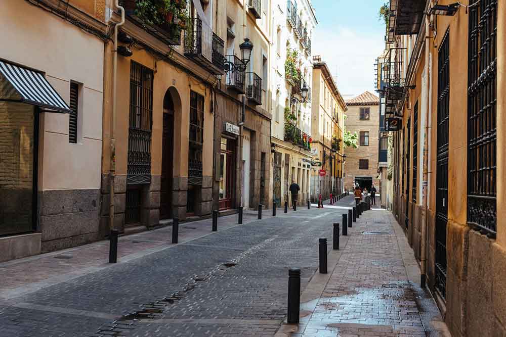 The vibrant street of Literary Quarter in Madrid, adorned with brown and pastel orange architecture that give a traditional Spanish feeling