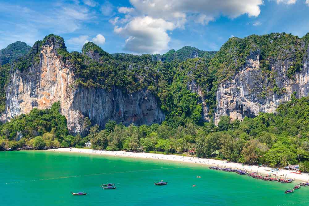 A high cliff with trees, offering a scenic view of the sea at Railay Beach in Krabi