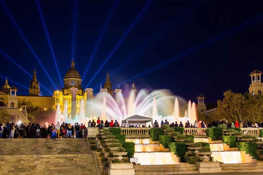 Barcelona Bucket List: 32 Best Things to Do in Barcelona, Spain 21 People watch the Magic Fountain of Montjuïc in Barcelona with its dancing fountains and colorful lights at night time