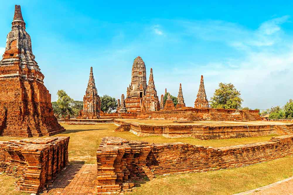 The old Ayutthaya ruins feature brown stones and walls against the backdrop of a clear blue sky