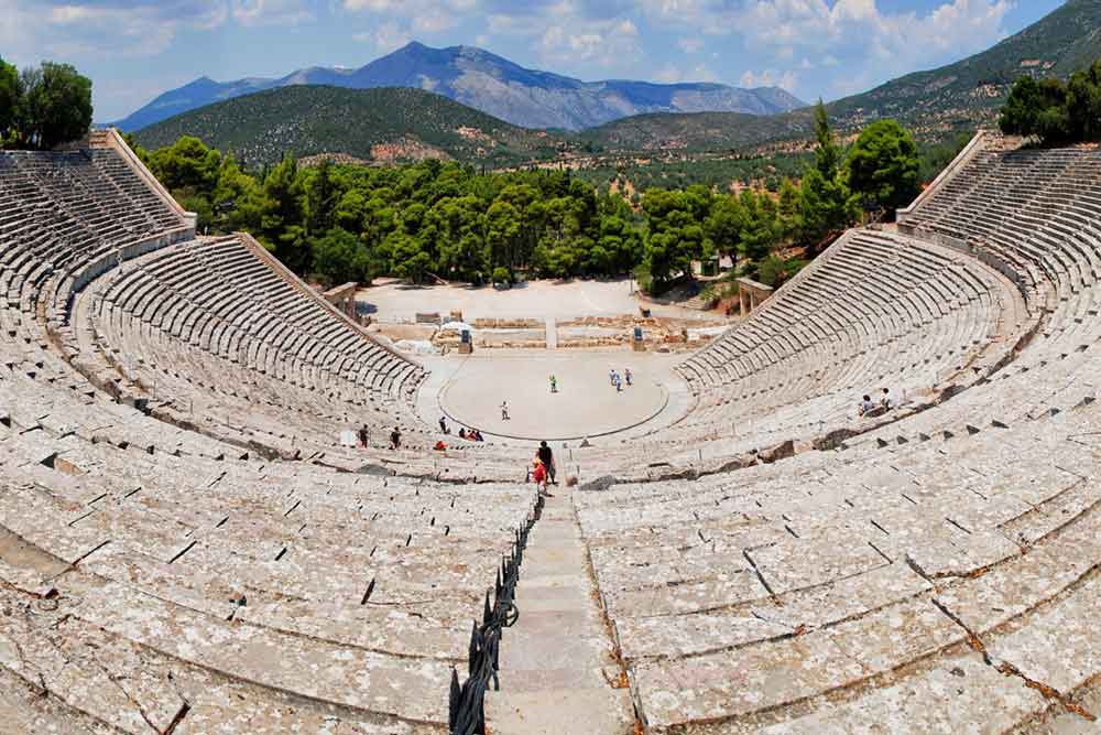The Ancient Theatre of Epidaurus with a view of trees and mountains