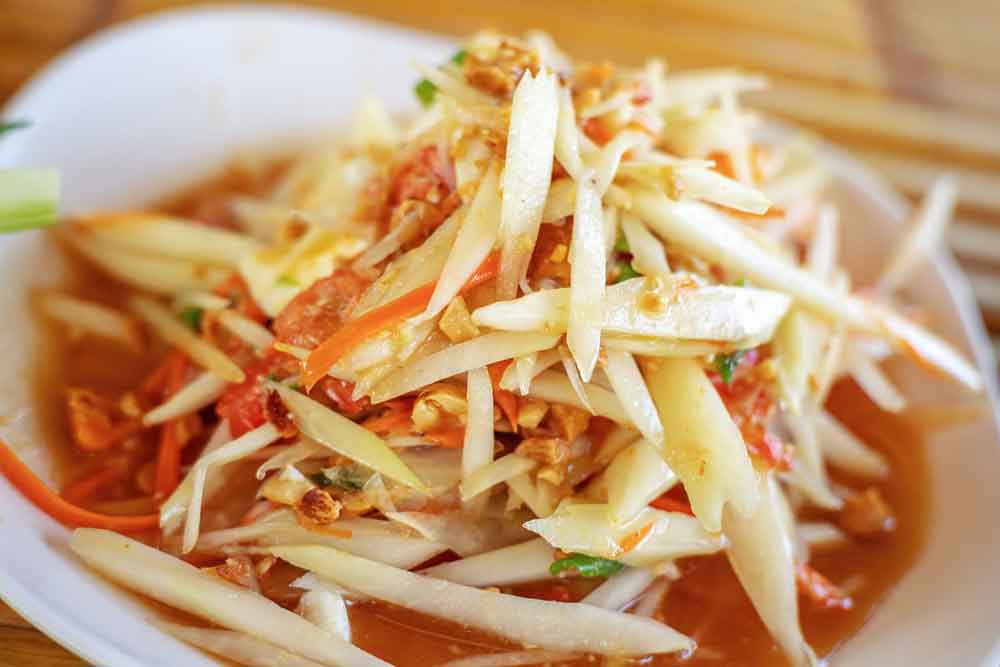 A plate of crunchy strips of unripe green papaya with fresh chiles