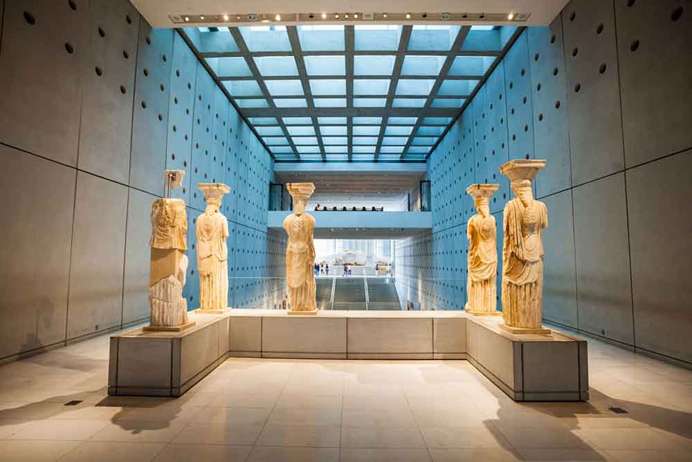 Five carved statues standing inside the Acropolis Museum