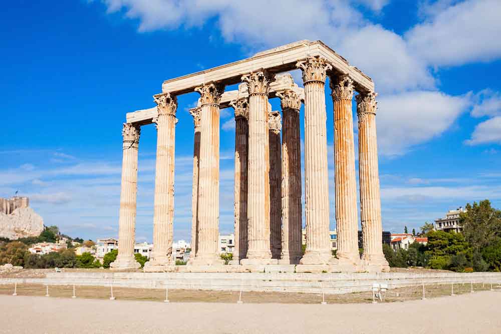 The temple of Olympian Zeus - a temple made of limestone and marble following the design of Doric style with columns firmly standing on the ground under a clear blue sky
