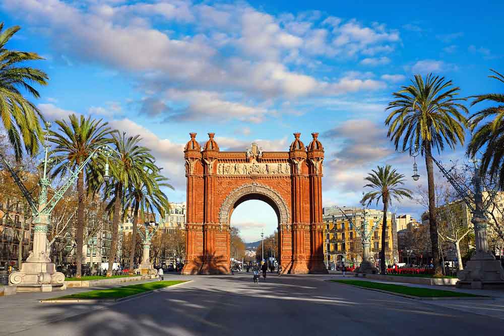 Barcelona Bucket List: 32 Best Things to Do in Barcelona, Spain 11 The Arco de Triunfo de Barcelona, with its brown-orange color, stands in the middle and is surrounded by trees and buildings